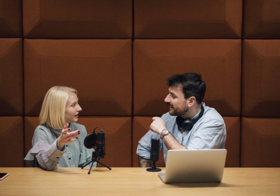 Two people recording a podcast with microphones.